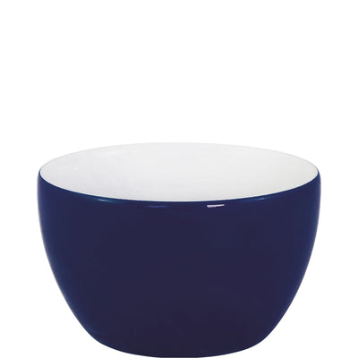 Eine runde Schüssel mit glänzender, tiefblauer Außenseite und weißen Innenseite. Die Schüssel hat eine glatte, moderne Form und steht auf einer flachen Oberfläche. Der Kontrast zwischen der blauen und der weißen Farbe sorgt für einen stilvollen, eleganten Look. Sie eignet sich sowohl für die Präsentation von Speisen als auch als dekoratives Element.