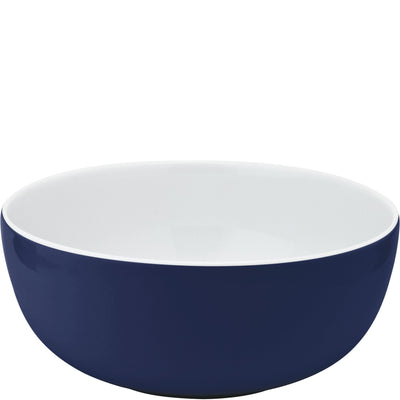 Eine runde Schüssel mit glattem, glänzendem, dunkelblauen Äußeren und einem weißen Innenraum. Die Schüssel hat eine sanfte, geschwungene Form und ist aus Keramik gefertigt. Ideal für Servieren oder Zubereiten von Speisen.