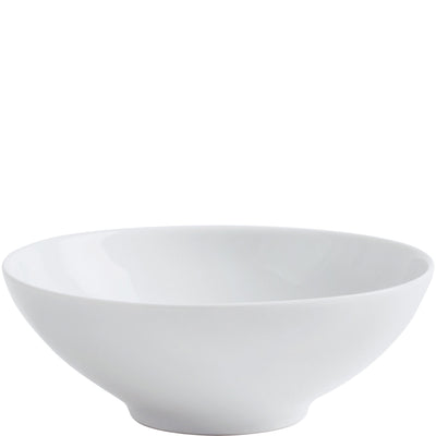 Schlichte, weiße Keramikschüssel mit breitem Rand und flacher Innenfläche. Die Schüssel ist rund und hat eine glatte Oberfläche, die das Licht reflektiert. Sie steht auf einem ebenen Untergrund und ist ideal zum Servieren von Salaten, Suppen oder Beilagen geeignet.