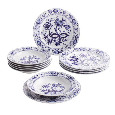 Ein Set aus mehreren weißen Tellern mit blauem, floralen Motiv. Es besteht aus einem flachen Teller und mehreren tiefen Tellern, die übereinander gestapelt sind. Der flache Teller ist mit einem detaillierteren Muster verziert, während die tiefen Teller ein ähnliches, jedoch einfacheres Design aufweisen. Die Teller haben einen klaren, klassischen Stil, der gut für Tischdekorationen geeignet ist.