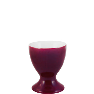 Ein elegantes, tief purpurfarbenes Eierbecher-Design mit einer glatten Oberfläche. Die Form ist geschwungen, mit einer schmalen Basis und einem breiteren oberen Rand, der nach außen gewölbt ist. Das Innere ist weiß, was einen schönen Kontrast zur äußeren Farbe bietet. Ideal für den Frühstückstisch, um weichgekochte Eier stilvoll zu präsentieren.