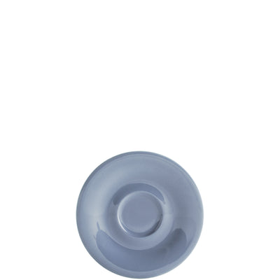 Eine runde, flache, hellblaue Untertasse aus Keramik ist im Bild. Die Tassenfläche ist glatt und glänzend, der Rand leicht nach oben gebogen. Im Zentrum der Untertasse befindet sich eine subtile Vertiefung, die für eine Tasse vorgesehen ist. Der Hintergrund ist schlicht und unauffällig, wodurch die Untertasse im Fokus steht.