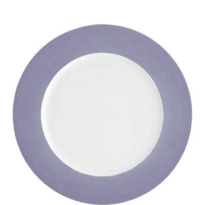 Ein runder Teller mit einer weißen Mitte und einem lila Rand. Der Rand ist einheitlich gefärbt und hat eine matte Oberfläche, während die Telleroberfläche glänzt. Der Teller könnte für Servieren oder Dekorationszwecke verwendet werden und vermittelt ein modernes, schlichtes Design.