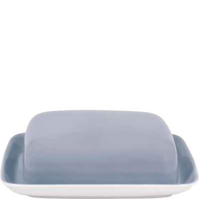 Ein quadratisches, gedecktes Buttergeschirr in sanftem Grau mit weißem Boden. Die geschwungene Form des Deckels und die schlichten Kanten verleihen dem Geschirr ein modernes Design. Es eignet sich zum stilvollen Servieren von Butter oder Aufstrichen und fügt sich harmonisch in eine gedeckte Tafel ein.