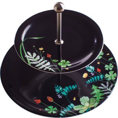 Ein zweistufiges Geschirr aus schwarzem Porzellan mit einem Edelstahlgriff in der Mitte. Beide Etagen sind mit bunten Pflanzenmotiven, darunter grüne Blätter, rote Beeren und blaue Blüten, dekoriert. Das Geschirr ist elegant und eignet sich ideal für die Präsentation von Snacks oder süßem Gebäck.