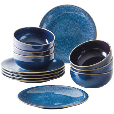 Eine Anordnung von blauem Geschirr, einschließlich mehrerer stapelbarer Schalen und Teller. Im Vordergrund liegen zwei flache Teller, während im Hintergrund gestapelte Schalen und weitere Teller zu sehen sind. Alle Teile sind in einem tiefen Blauton mit einer goldenen Randverzierung gehalten.