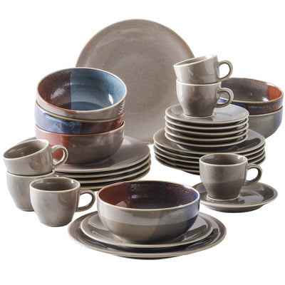 Mehrere Geschirrsets in verschiedenen Größen und Farben auf einem weißen Hintergrund. Zu sehen sind Teller, Schalen und Tassen, die aus einem grauen Material mit farbigen Akzenten bestehen. Einige Tassen sind gestapelt, während andere aufrecht stehen. Die Geschirrteile sind sorgfältig angeordnet und bieten eine ansprechende, moderne Optik.