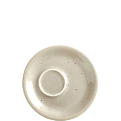 Ein runder, schlichter Unterteller aus Keramik in einem sanften, grauen Farbton. Die Oberfläche zeigt kleine, unregelmäßige Farbnussspuren, die dem Teller einen handgemachten Charakter verleihen. In der Mitte befindet sich ein erhöhter Bereich für die Tasse. Der Teller hat eine durchgehend glatte Oberflächenstruktur, die einen minimalistischen und modernen Eindruck vermittelt. Ideal für den Einsatz in der Küche oder beim Servieren von Getränken.