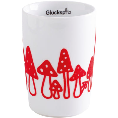 Eine weiße Kaffeetasse mit bunter Grafik. Am oberen Rand der Tasse steht der Schriftzug "Glückspitz". Der untere Teil der Tasse ist mit roten Pilzen in verschiedenen Formen und Größen dekoriert, die stilisiert und verspielt aussehen. Die Tasse hat eine schlichte, moderne Form und ist für den Einsatz im Alltag geeignet.
