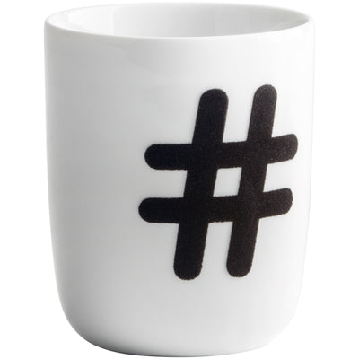Ein weißer Keramikbecher mit einem schwarzen Hashtag-Symbol (#) auf der Vorderseite. Der Becher hat eine schlichte, moderne Form und eignet sich gut für den täglichen Gebrauch. Er kann für heißen oder kalten Getränken verwendet werden und verfügt über einen stabilen Rand. Der Kontrast zwischen dem weißen Hintergrund und dem schwarzen Symbol sorgt für eine ansprechende Optik.