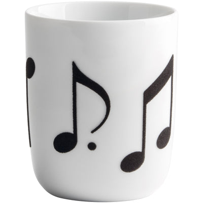 Ein weißer Porzellanbecher mit schwarzen Notenmotiven. Die Musiknoten sind stilisiert und verteilen sich gleichmäßig über die Oberfläche des Bechers. Der Becher hat eine schlichte Form und ist für Heißgetränke geeignet. Ideal für Musikliebhaber oder als dekoratives Element für den Tisch.