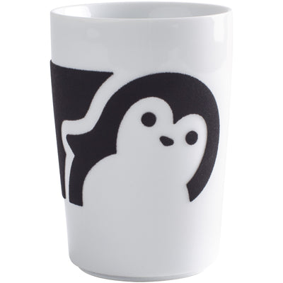 Eine weiße Tasse mit einem stilisierten, schwarzen Pinguin-Emotiv. Der Pinguin hat eine runde Kopfkontur und große, freundliche Augen. Die Tasse hat eine schlichte, moderne Form ohne Henkel und steht auf einem neutralem Untergrund.