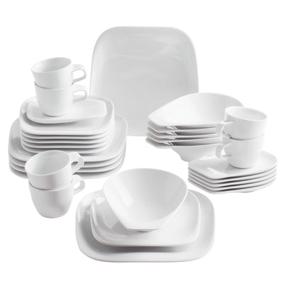 Ein Set aus weißem Geschirr, bestehend aus verschiedenen Tellern, Schalen und Tassen. Auf der linken Seite sind mehrere kleine Kaffeetassen mit Untertassen gestapelt, während daneben flache und tiefe Teller in unterschiedlichen Größen ordentlich angeordnet sind. In der Mitte steht eine größere, viereckige Schüssel. Der Hintergrund ist neutral, wodurch das Geschirr im Vordergrund gut zur Geltung kommt.