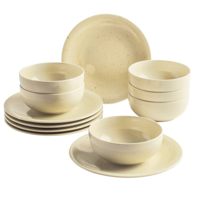 Eine elegante Geschirrset-Anordnung mit mehreren weißen, leicht strukturierten Tellern und Schalen. Im Vordergrund stehen zwei tiefere Schalen, während im Hintergrund drei flache Schalen und mehrere Teller übereinander gestapelt sind. Die Geschirrteile haben eine schlichte, gefrostete Oberfläche mit kleinen speckled Mustern und strahlen eine warme, neutrale Farbe aus.