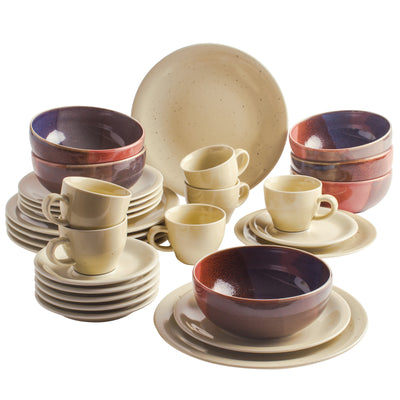 Ein buntes Geschirrset, bestehend aus mehreren Tellern, Schalen und Tassen. Die Schüsseln sind in verschiedenen Farben gehalten, darunter Violett und Rot, während die anderen Teile in einem neutralen Beige-Ton gestaltet sind. Die Teile sind übereinander gestapelt und angeordnet, wobei große und kleine Teller sowie Tassen sichtbar sind. Das Gesamtbild vermittelt eine einladende und farbenfrohe Atmosphäre, ideal für eine Mahlzeit oder Zusammenkunft.