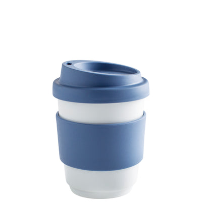 Blauer wiederverwendbarer Kaffeebecher mit weißem Innenteil. Der Becher hat eine dünne graue Silikonummantelung, die eine rutschfeste Handhabung ermöglicht. Der Deckel hat eine Aussparung für den Trinkhalm und ist ebenfalls in einem passenden Blauton gehalten. Der Becher steht auf einer hellen Unterlage.