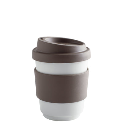 Ein wiederverwendbarer Kaffeebech, bestehend aus einer weißen Keramiktasse mit einem braunen Silikonrand und einem Deckel. Der Becher hat eine quadratische Form und ist für den Gebrauch unterwegs geeignet. Der Deckel hat eine kleine Öffnung, die das Trinken erleichtert.