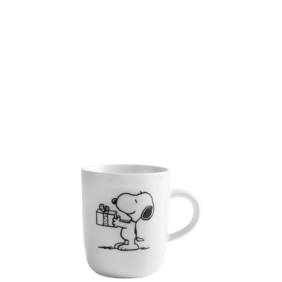 Weißer Kaffeebecher mit einer Illustration des Comic-Charakters Snoopy, der ein Geschenk hält. Die Zeichnung zeigt Snoopy in Seitenansicht, mit einem fröhlichen Ausdruck und einem kleinen Paket in seinen Pfoten. Der Becher hat eine runde Form und einen festen Henkel auf der rechten Seite. Der Hintergrund ist schlicht, um den Fokus auf die pitschige Darstellung zu lenken. Ideal für Fans von Snoopy und den Peanuts-Comics.