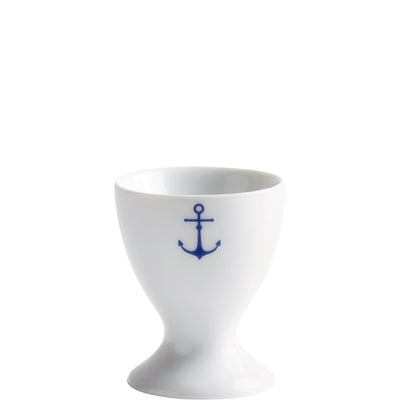 Ein eleganter, weißer Eierbecher aus Porzellan mit einer blauen Anker-Dekoration auf der Vorderseite. Der Becher hat eine schlanke, tulpenförmige Basis und eine breite Öffnung, die für das Halten von Eiern geeignet ist. Ideal für den Frühstückstisch und maritime Themen.
