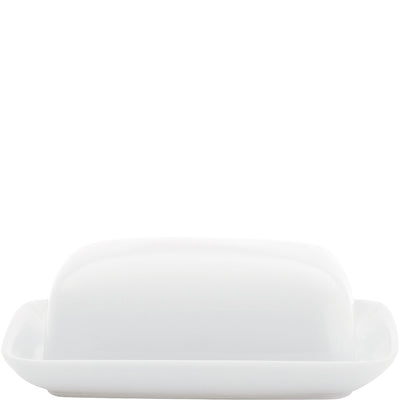 Weiße Porzellan-Butterdose mit einem flachen, rechteckigen Unterteil und einem leicht gewölbten Deckel. Die Dose steht auf einem weißen Hintergrund und reflektiert leicht das Licht. Ideal für die Aufbewahrung und Präsentation von Butter auf dem Tisch.