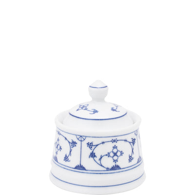 Weißes Porzellan-Behältnis mit einem Deckel, verziert mit blauen Blüten- und Blattmotiven. Der Behälter hat einen runden, breiten Fuß und eine leicht geschwungene Form. Der Deckel ist spitz zulaufend mit dekorativen Details. Diese Art von Geschirr eignet sich gut für die Aufbewahrung von Zucker oder Gewürzen. Der Hintergrund ist neutral, was den Fokus auf das Porzellanobjekt legt.