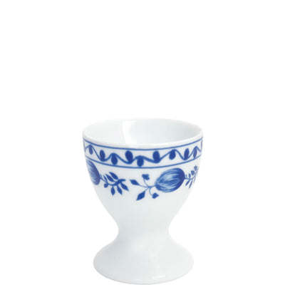 Weißes Eierbecher aus Porzellan mit blauer floral gemusterter Verzierung. Die Form ist schalenartig mit einem breiten Fuß, der stabil steht. Die Kante ist leicht gewellt, was dem Eierbecher ein elegantes Design verleiht. Ideal für das Servieren von weichgekochten Eiern zum Frühstück oder zum dekorativen Einsatz auf einem Tisch.