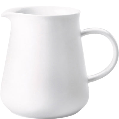 Weißes Keramik-Behältnis mit einem geschwungenen Ausguss und einem stabilen Henkel. Die Form ist modern und elegant, mit einem breiten, abgerundeten Boden, der nach oben hin schmaler wird. Das Material wirkt glatt und glänzend, ideal für Servieren von Flüssigkeiten wie Milch oder Sahne. Der Hintergrund ist neutral, um das Augenmerk auf den Krug zu lenken.
