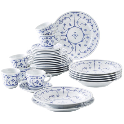Eine Sammlung von Porzellan-Geschirr in Weiß mit blauen floralem Muster. Die Anordnung umfasst mehrere flache und tiefe Teller, Schüsseln und Kaffeetassen, die aufeinander gestapelt und daneben platziert sind. Im Hintergrund ist ein großer flacher Teller zu sehen, der ebenfalls das blaue Muster zeigt. Das Geschirr ist elegant und eignet sich für festliche Anlässe.